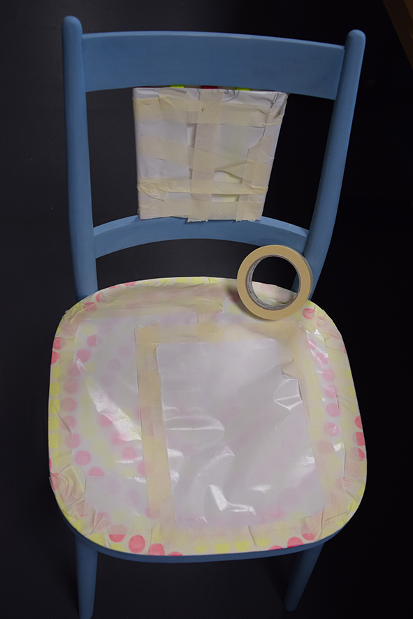 Sedaciu časť stoličky a tyčky na operadle prekryjeme odpadovým papierom a lepiacou pásku, aby sme ich neskôr nezafarbili.